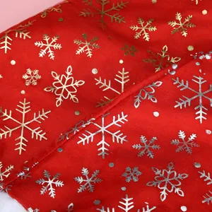 Dettaglio macro di fiocchi di neve oro e argento su tessuto di velluto rosso di Natale.