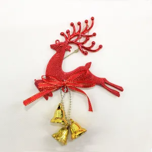 Close-up detail of red Christmas reindeer ornament with golden bells and bow tie