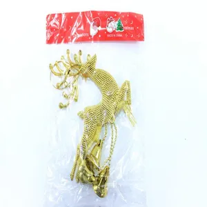 Macro detail of golden reindeer Christmas tree ornament with hanging jingle bells