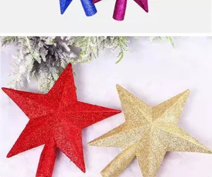 Red and gold glittery Christmas tree topper stars on festive snowy background