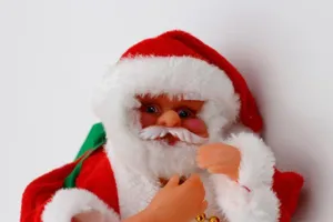 Detalle del muñeco eléctrico de Papá Noel de peluche con gorro rojo y barba blanca