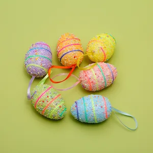 Detailed macro view of colorful foam beaded Easter egg hanging ornaments on green background