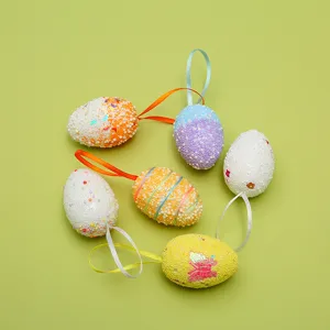 Decorative colorful foam Easter eggs with hanging ribbons on a pale green background