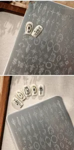 Macro detail of stainless steel nail stamping plate TG-043 featuring vintage engraved designs