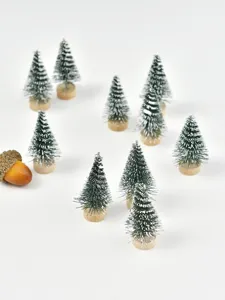 Primer plano de mini árboles de Navidad nevados con bases de madera decorativas