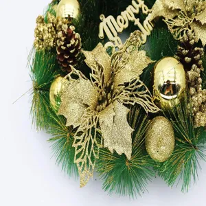 Close-up detail of a green Christmas wreath featuring gold poinsettias and baubles