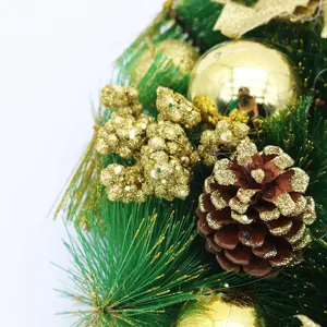 Close-up detail of a festive Christmas wreath featuring gold glitter pinecone and baubles
