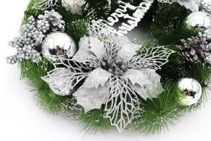 Detailed view of a silver Christmas wreath with poinsettias, baubles and pine cones