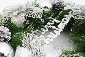Macro detail view of a silver Christmas wreath featuring glitter flowers and baubles