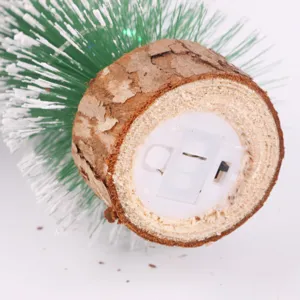 Primer plano de la base de madera de un mini árbol de Navidad LED con interruptor