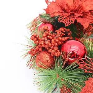Close-up of red glittery berries and poinsettia on a festive Christmas wreath detail.