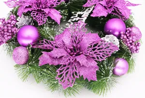 Detail of purple Christmas wreath with glitter poinsettias and purple baubles