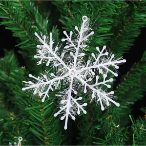 Primer plano de un copo de nieve decorativo de plástico blanco en un árbol de Navidad