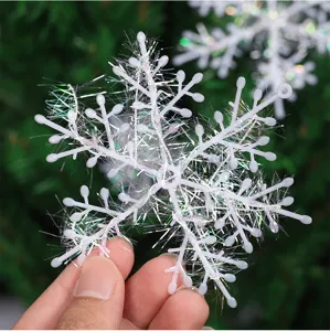 Primer plano detallado de un adorno de copo de nieve blanco con flecos iridiscentes.