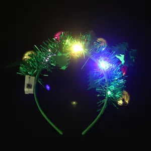 Close-up of glowing LED Christmas headband with green tinsel and festive ornaments