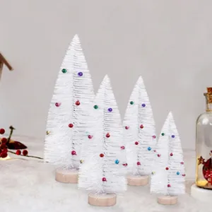 Detalle de cuatro mini árboles de Navidad blancos con bolas de colores y base redonda de madera.