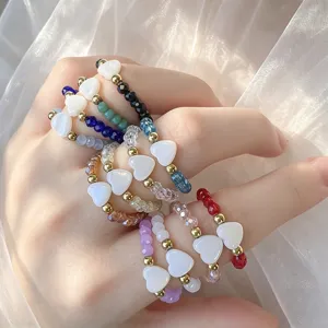 Close-up detail view of 12 colorful elastic heart rings with shell hearts and crystal beads