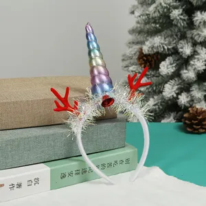 Christmas headband with rainbow unicorn horn and red reindeer antlers on a stack of books