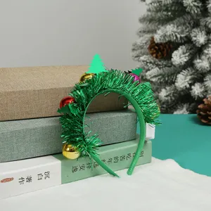 Macro view of festive green tinsel Christmas headband with colorful ornaments and mini tree.