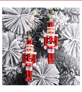 Detailansicht von zwei roten Nussknacker-Anhängern an einem verschneiten Weihnachtsbaum.