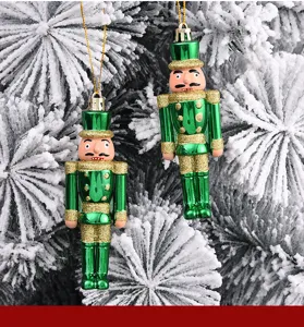 Nahaufnahme von grün-goldenen Nussknacker-Soldaten an einem verschneiten Weihnachtsbaum