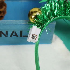 Close-up detail of the battery box and switch on a green tinsel Christmas headband