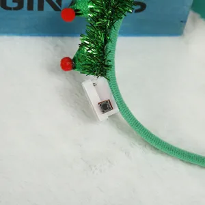 Detail shot showing the white battery pack and black switch on a festive Christmas tree headband.