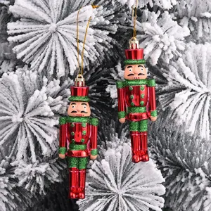 Dekorative bemalte Nussknacker-Soldaten-Anhänger an einem schneebedeckten Weihnachtsbaum