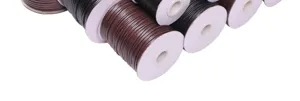Macro detail view of multiple spools of Korean waxed cord in dark brown and black colors