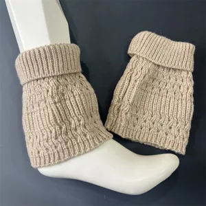 Detailed shot of beige knitted wool leg warmers with vertical stripes and soft cuff design.