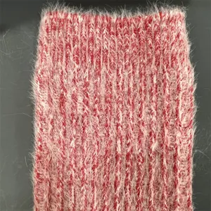 Close up view of fuzzy knit wool sock fabric, showing soft texture and cozy red white patterns.