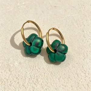 Detailansicht von Gold-Creolen mit grünen Blumenanhängern im Malachit-Muster