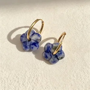 Detailansicht von blau marmorierten Steinblumen-Anhängern an goldenen Creolen aus Edelstahl