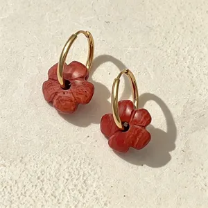 Detailansicht von böhmischen Ohrringen mit roten Steingeblüten und goldfarbenem Reifen.