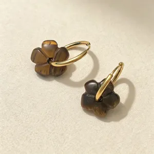 Nahaufnahme von Creolen aus Edelstahl im Boho-Stil mit braunen Steinen in Blumenform