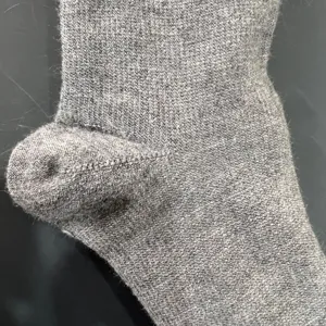 Merino wol gebreide sok detail weergave met zachte grijze hielstructuur en naadloos ontwerp.