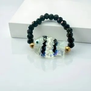 Dettaglio dell'anello elastico in stile marino con una simpatica perla a forma di pesce in vetro
