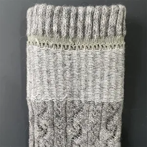 Close-up of grey wool knit sock detail, showing ribbed cuff, mesh, and cable pattern.
