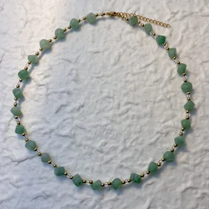 Detailed view of handmade necklace with green natural stone cube beads and gold accents