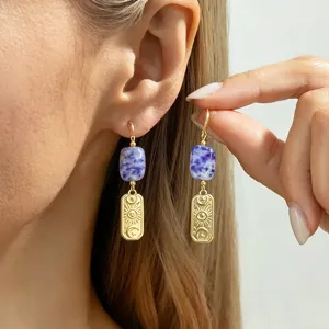 Close-up of vintage stainless steel earrings with purple natural stone and celestial eye charms