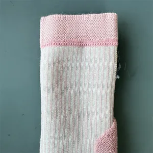 Detailed view of merino wool sports sock with pink white stripes and ribbed cuff design.