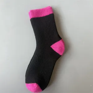 Detailed view of the merino wool thick warm women's mid-tube socks in black and pink.