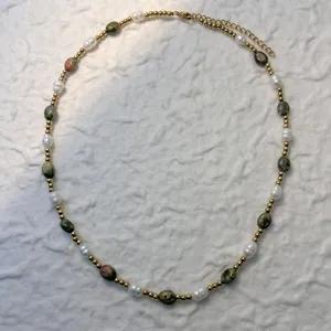 Detail view of a natural freshwater pearl and mixed stone necklace with gold beads.