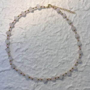 Close-up of irregular natural rose quartz stones and gold-plated beads on a necklace
