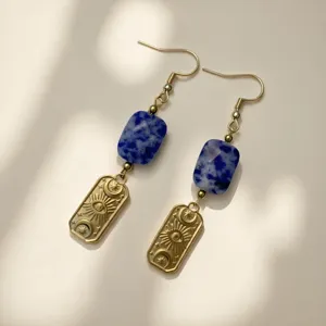 Detailed close-up of vintage earrings with blue stone and engraved eye charm