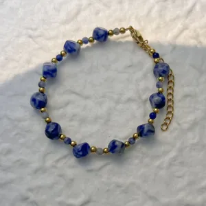 Elegant blue marbled square beads and gold metal beads bracelet detail for beach wear