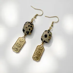 Detail shot of vintage stainless steel earrings with natural dalmatian stone and eye motifs