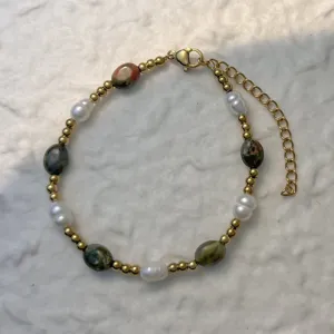 Close-up of mixed natural stone and freshwater pearl beaded bracelet with gold clasp