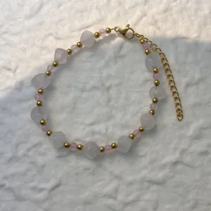 Detail view of beaded bracelet with frosted stones and pink beads on white texture