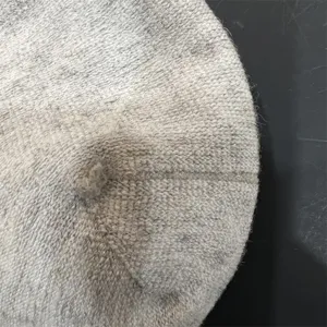 Grey knit beret detail close-up, premium wool texture surface, winter warm fashion hat.